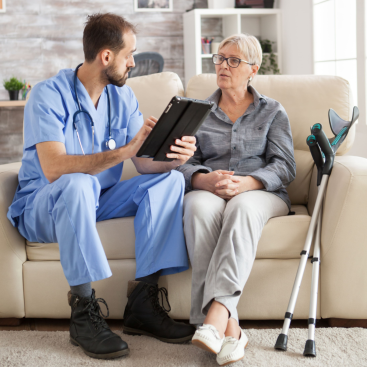 Medico atendiendo anciana en su hogar.